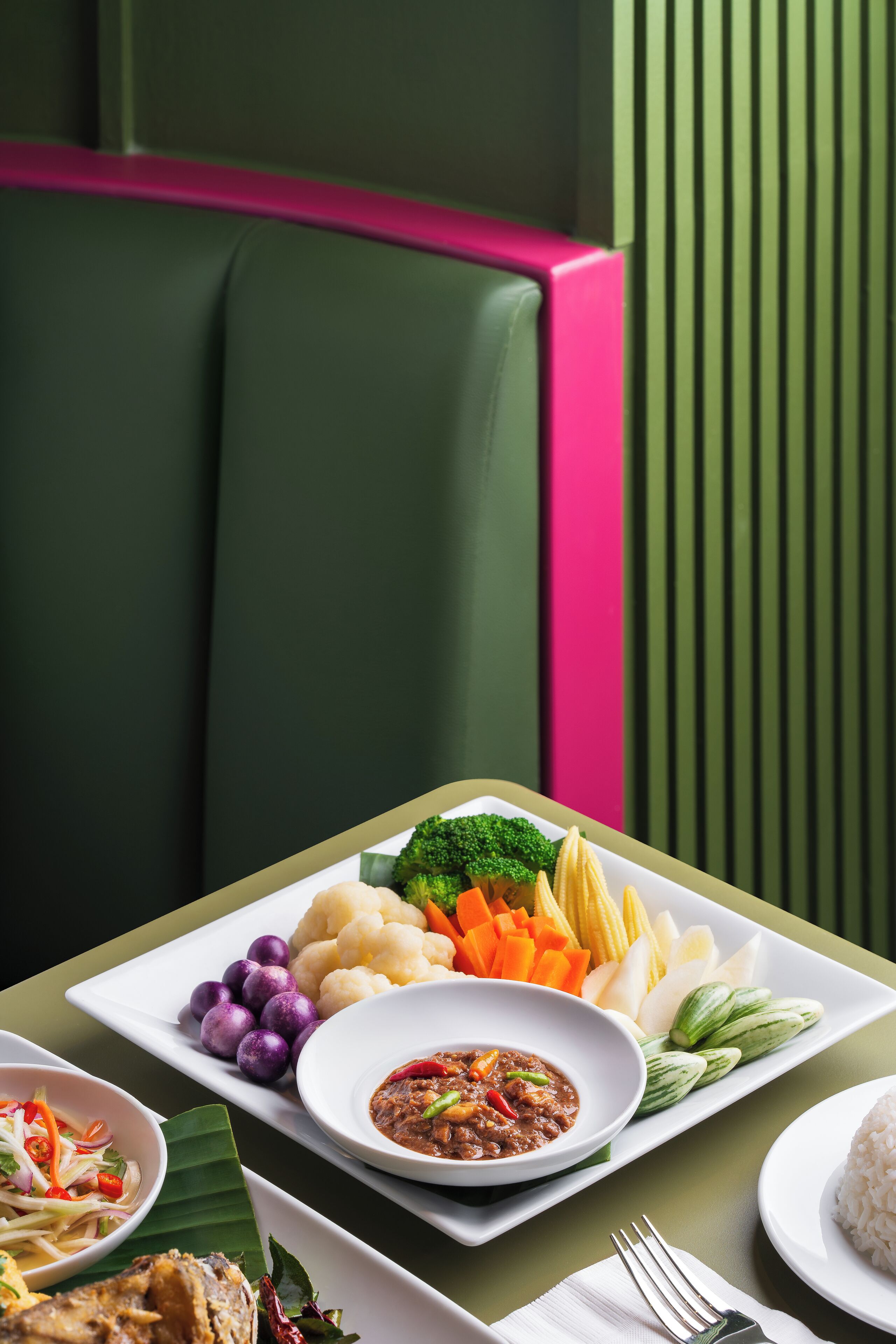 A dining table with a variety of dishes, including rice, vegetables, and a bowl of soup.