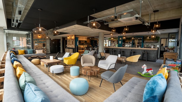 Een moderne zithoek met banken, stoelen en een bar.
