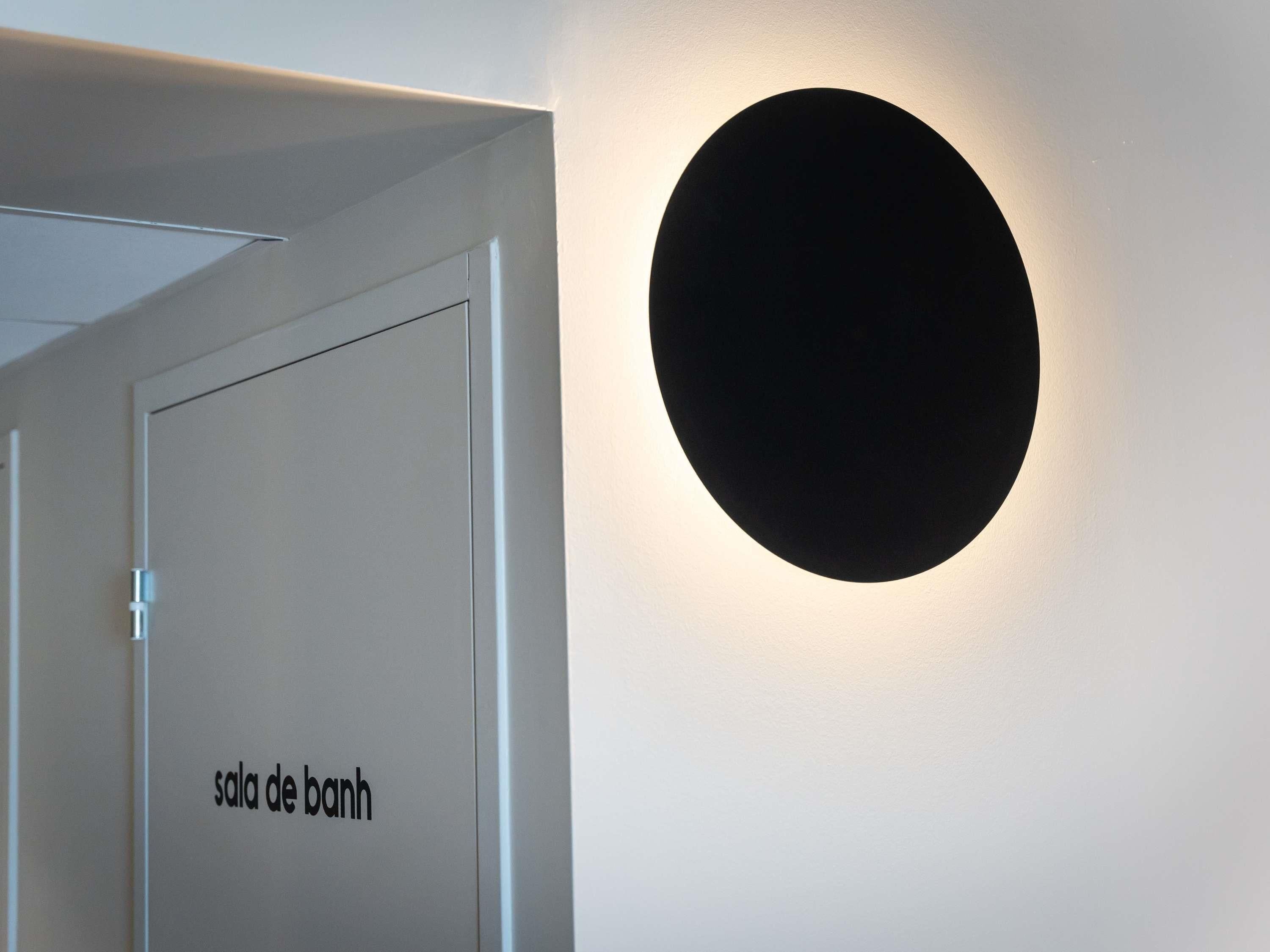 A door labeled "sala de bains" with a circular light fixture on the wall.