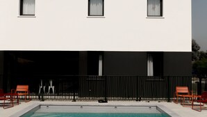 Een modern gebouw met een zwembad en terras.