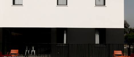 Un edificio moderno con piscina y mobiliario exterior.