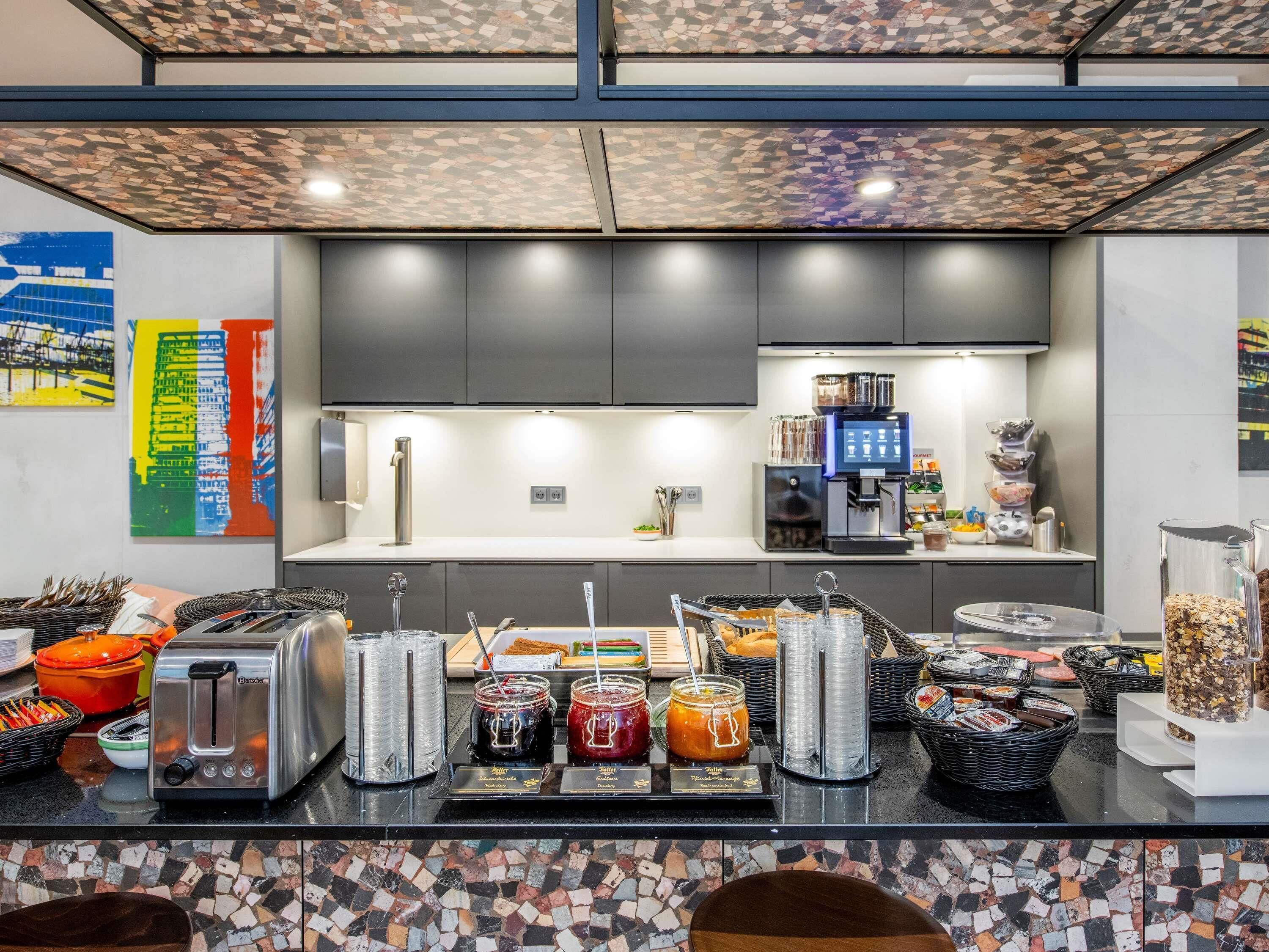 Una cocina moderna con cafetera, tostadora y diversos alimentos sobre la encimera.