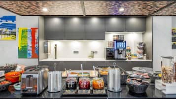 A modern kitchen with a coffee machine, toaster, and various food items on the counter.