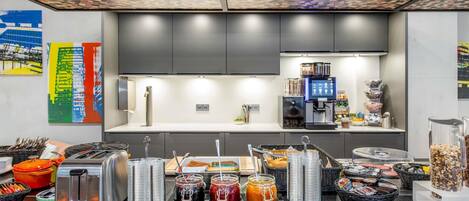 A modern kitchen with a coffee machine, toaster, and various food items on the counter.