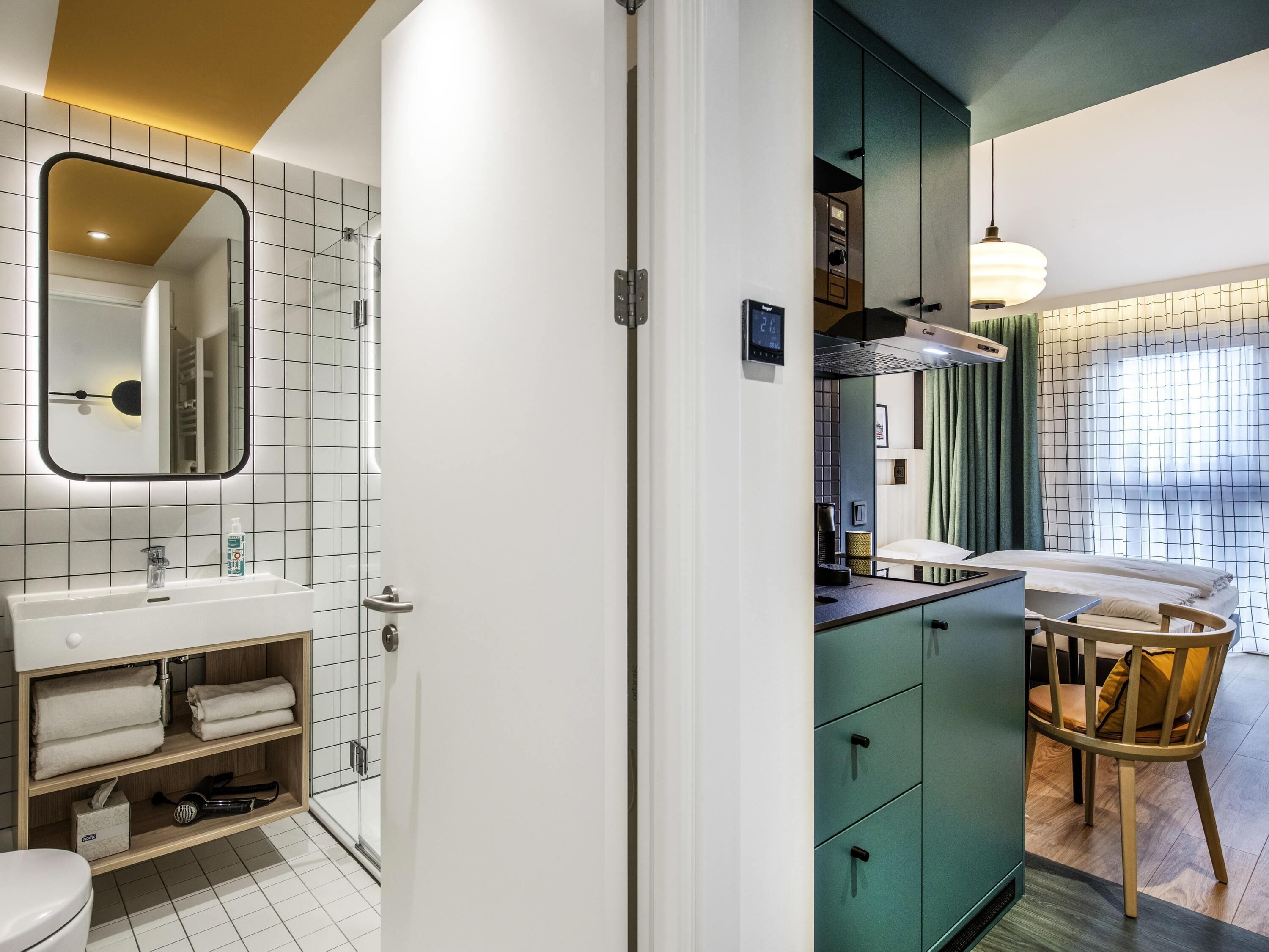 A modern bathroom with a white sink, mirror, and shelves with towels.