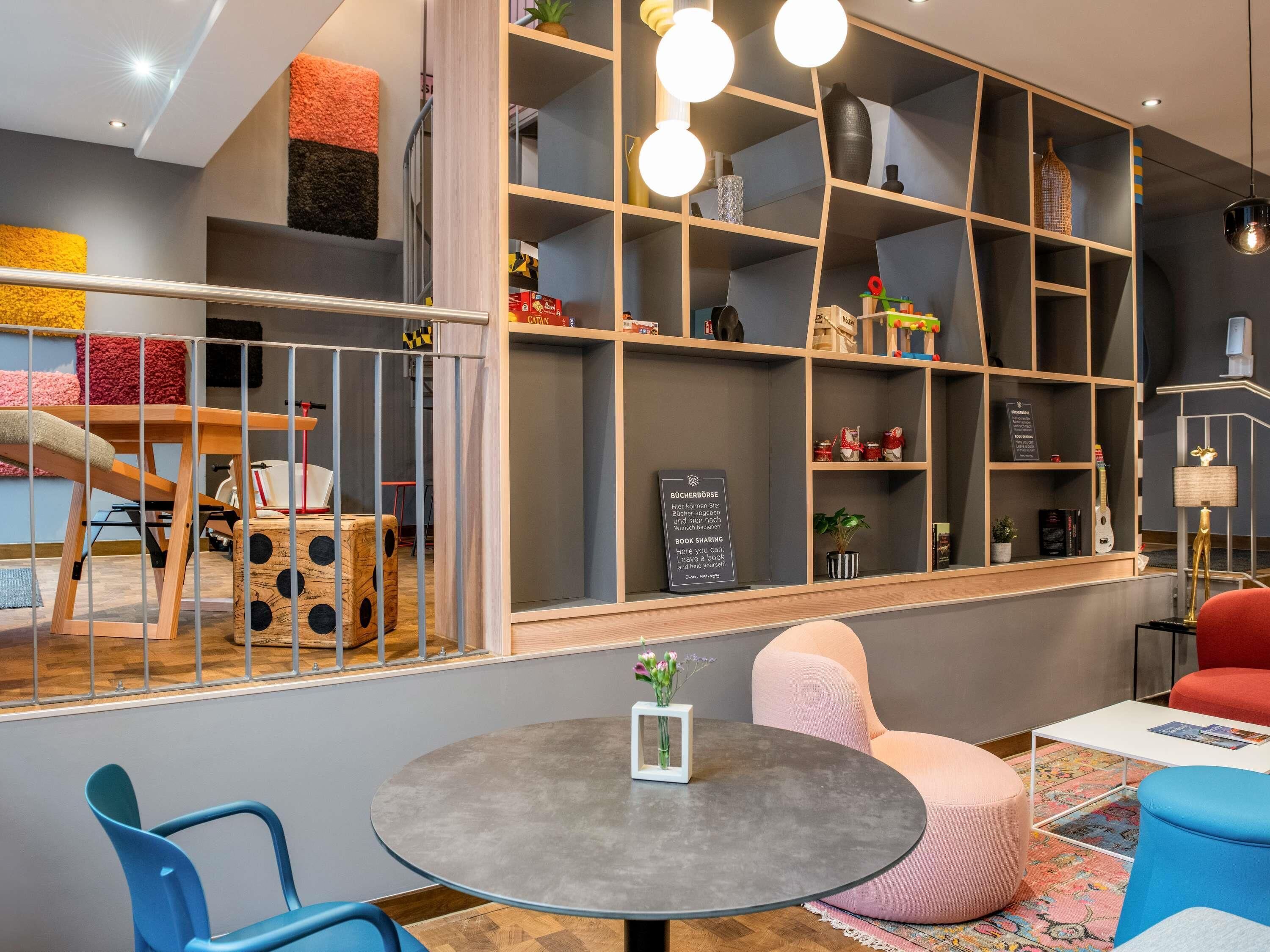 Un intérieur moderne avec une table ronde, des sièges et une bibliothèque contenant divers objets.