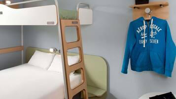 A bunk bed with a wooden ladder, a bedside table with a book, and a blue jacket hanging on a hook.
