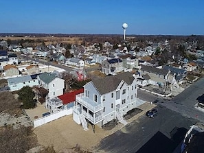 Une ville côtière qui se distingue par son imposant château d’eau, ses maisons aux toits de couleurs variées et son ciel dégagé.