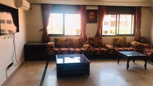 Uma sala de estar com sofá, mesa de centro e televisão.