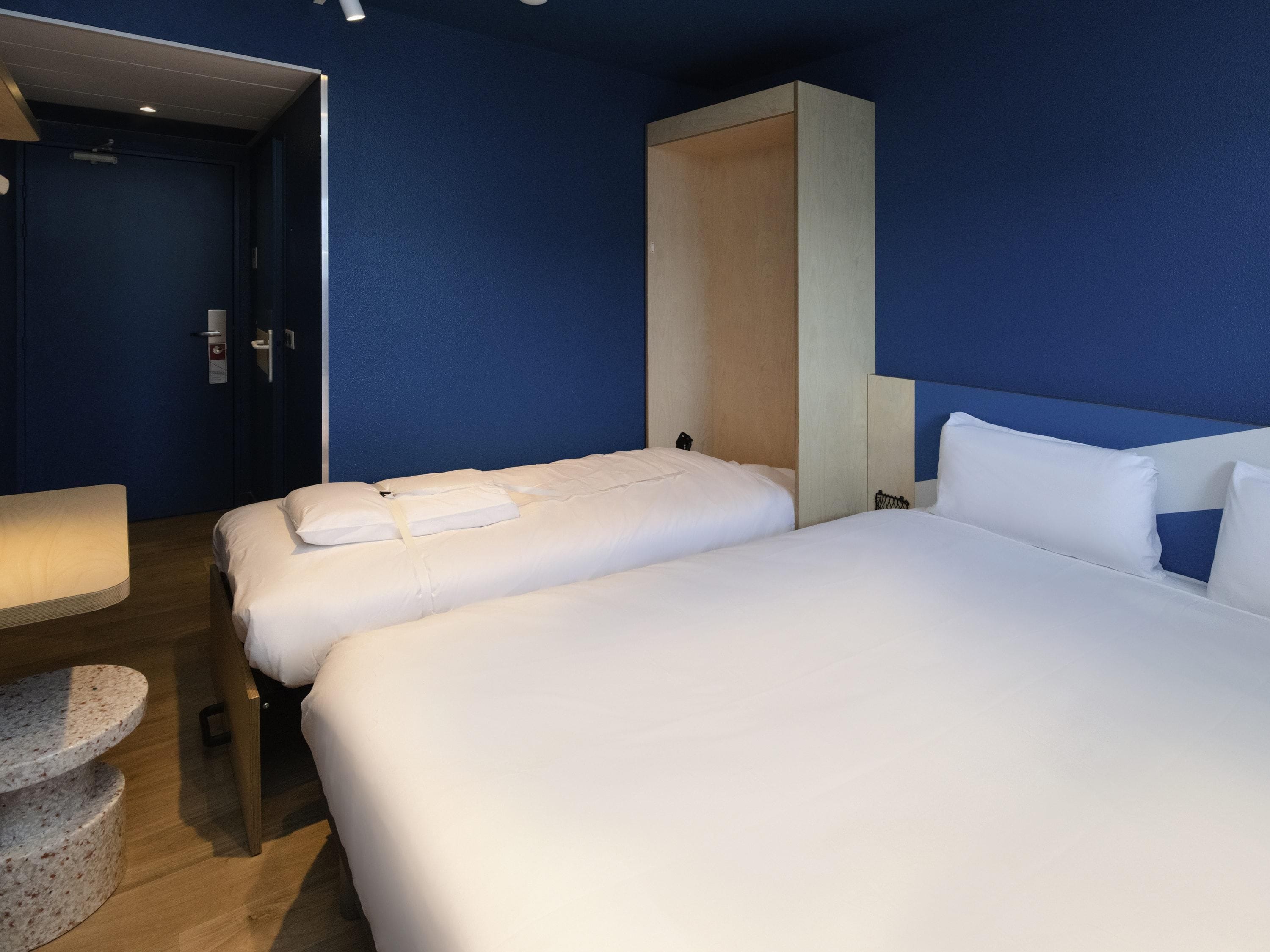 Habitación de hotel con dos camas, un escritorio y una silla.