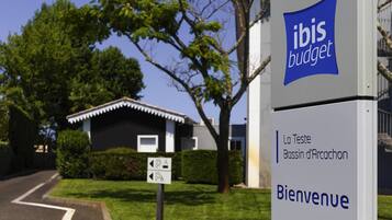 Ein Schild mit 'ibis budget' und 'Bienvenue', das ein Willkommenszeichen anzeigt.