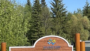 Un panneau en bois indiquant « Young’s Beach » et arborant le logo du comté de Lac La Biche.