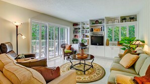 A spacious living area with a sofa, a coffee table, and a bookshelf. - Newly remodeled! Upscale Condo on the World-renowned Amelia Island Plantation! (Fernandina Beach)