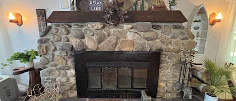 Una chimenea de piedra con un cartel encima que dice "RELAX en el LAGO".