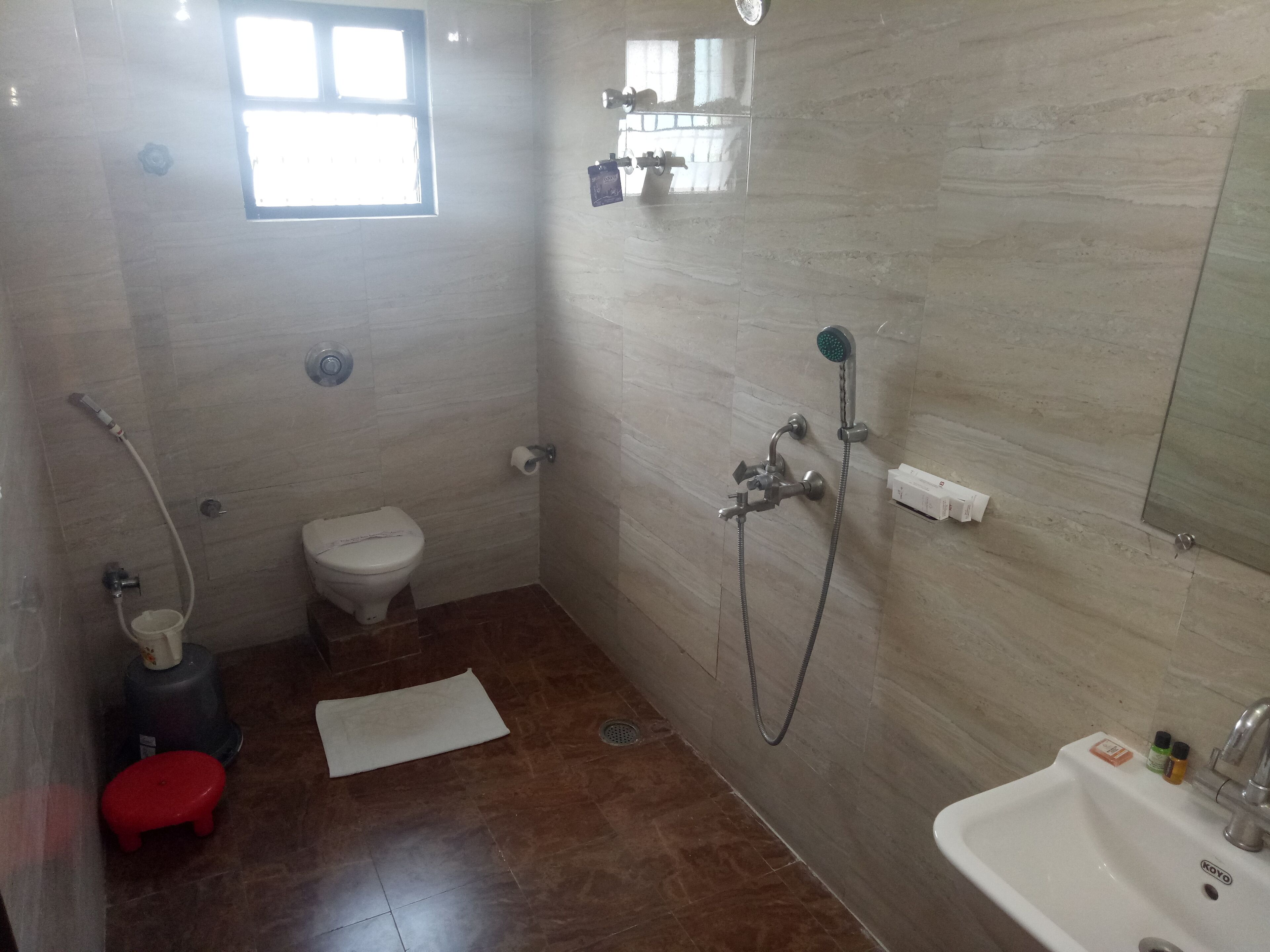 Un baño pequeño con azulejos, un inodoro, ducha y lavamanos.