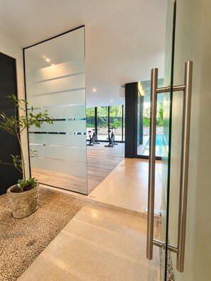 A modern interior with a sliding glass door leading to an outdoor area with exercise bikes.
