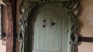 A green wooden door with intricate carvings and a brass doorknob. - Artistic barn: wood burning hottub, sauna and pizza oven  (Kent)