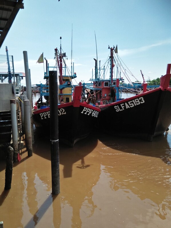Un puerto con dos barcos amarrados, uno con el número 'SLFA5193' y el otro con 'PPE 600'.