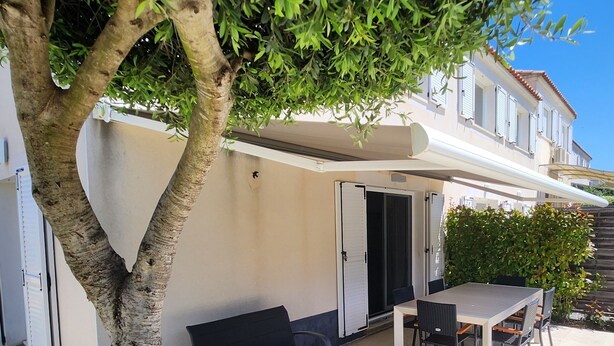 Un espace extérieur aménagé avec une table et des chaises, un canapé et un arbre.