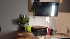 A kitchen with a wooden countertop, a bowl of fruit, a microwave, a sink, and a potted plant. - Happiness and calm to enjoy a magnificent view  (Marseille)