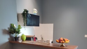 A kitchen with a bar area, two stools, a potted plant, a pitcher, and a fruit bowl. - Happiness and calm to enjoy a magnificent view  (Marseille)