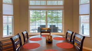 A dining area with a round table, chairs, and a chandelier. - Lakefront Getaway with Game Room and Theater Seating (Moses Lake)