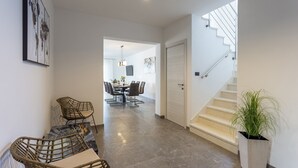 Un interior moderno con un comedor, una escalera y un pasillo.