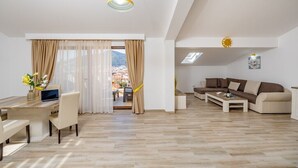 Ein modernes Wohnzimmer mit Essbereich, einer Sofagarnitur und Blick ins Freie.