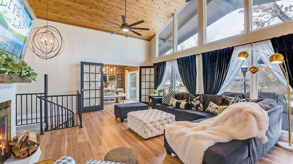 A spacious living room with a fireplace, a large window, and a cozy seating area.