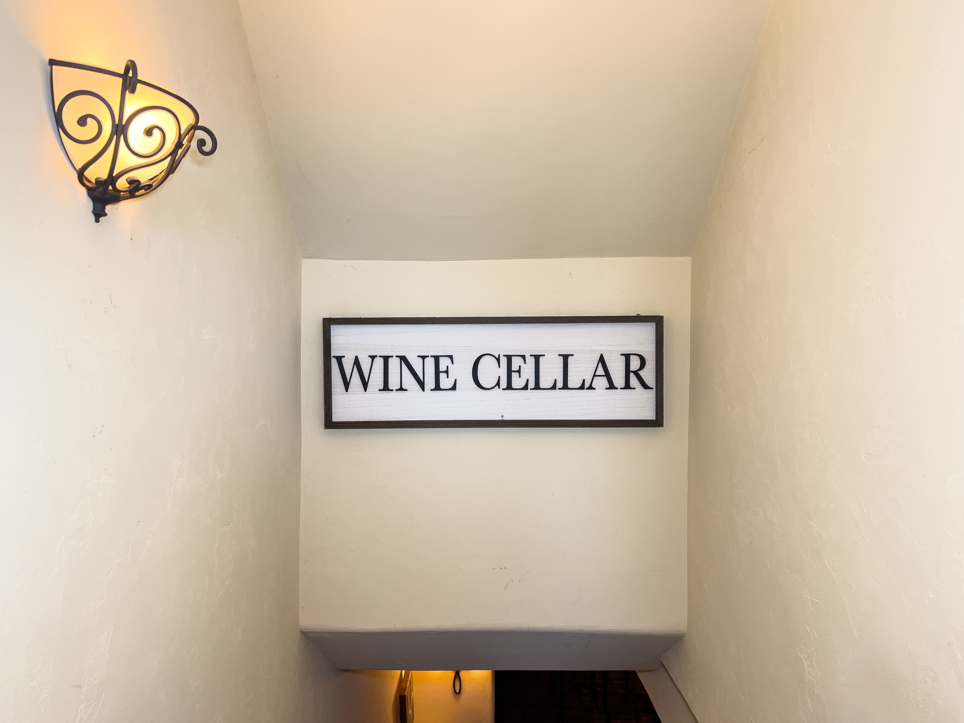 A wall-mounted sign reading "WINE CELLAR" in a hallway.