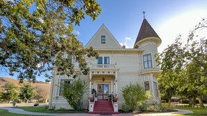A large, historic house with a prominent tower and a red front entrance. - Chateau Coralini (Salinas)
