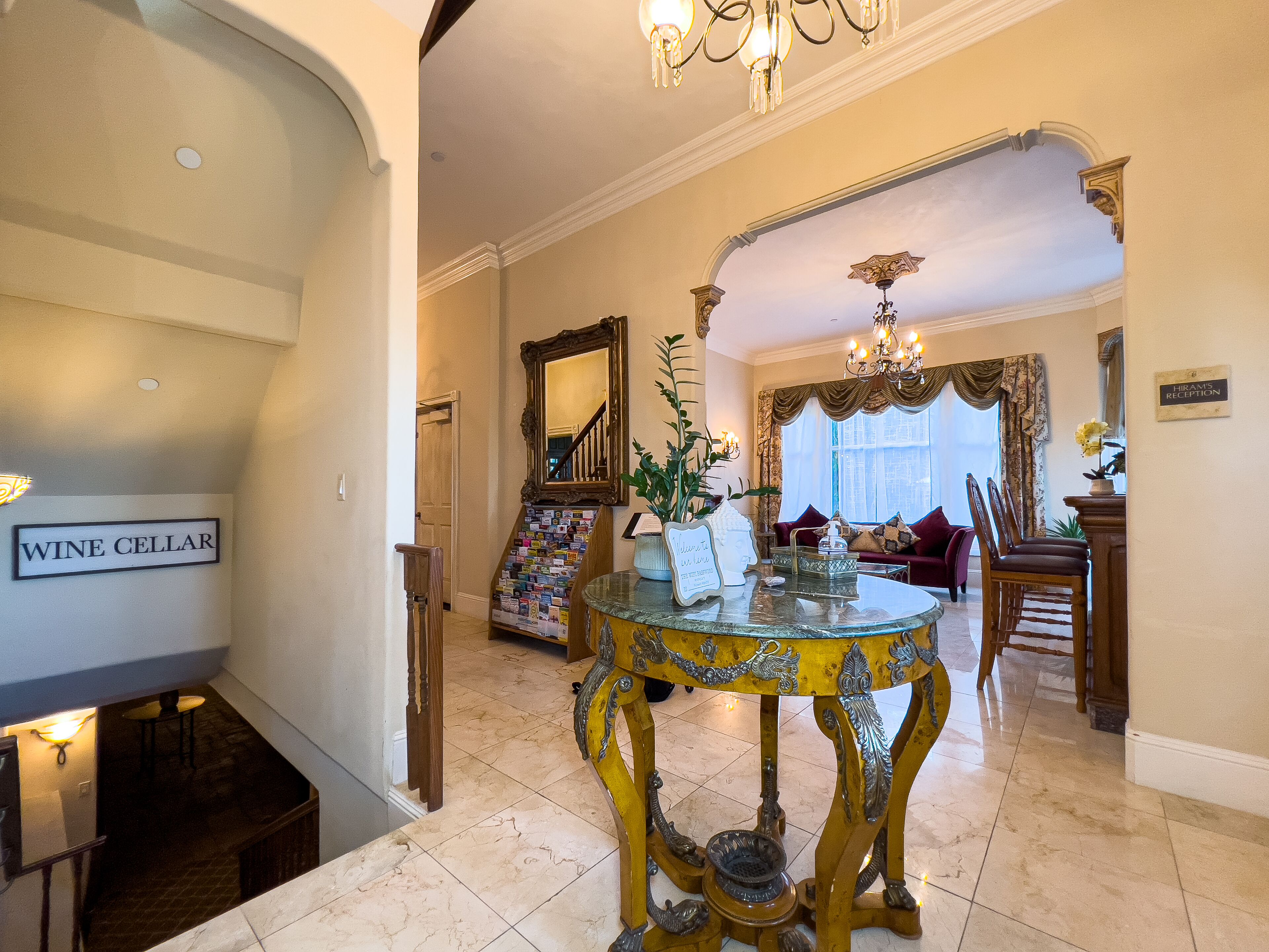 A grand lobby with a wine cellar sign, a decorative table, and a reception area.