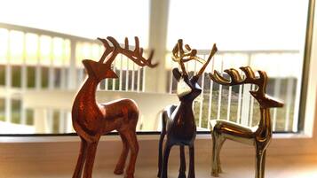 Three deer figurines on a windowsill.