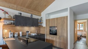 Una cocina moderna con armarios oscuros, una isla central y detalles de madera.