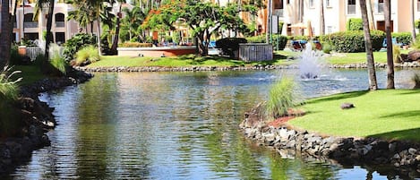 A calm water body with palm trees and a building in the background.