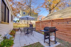 A patio with a table and chairs, a grill, and an umbrella. - Dreamy St Charles Retreat w/ Furnished Patio! (Saint Charles)