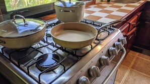 A kitchen with a gas stove, pots, and pans. - Beach house with a pool (Pavones)