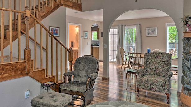 A spacious living area with a wooden staircase, two armchairs, and a dining table. - 8 Mi to Dtwn Achorage! Home w/ Pet-Friendly Yard (Anchorage)