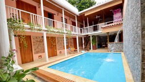 A pool area with a wooden deck, a covered seating area, and a stone wall. - CA-2 HABITACION CIUDAD ANTIGUA CARTAGENA (Cartagena)