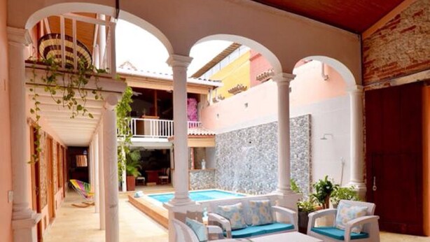 A spacious outdoor area with a pool, white wicker furniture, and a wooden ceiling. - CA-2 HABITACION CIUDAD ANTIGUA CARTAGENA (Cartagena)