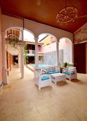 A spacious outdoor area with a pool, white wicker furniture, and a wooden ceiling. - CA-2 HABITACION CIUDAD ANTIGUA CARTAGENA (Cartagena)