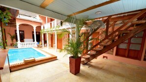 An indoor swimming pool with a wooden staircase and potted plants. - CA-2 HABITACION CIUDAD ANTIGUA CARTAGENA (Cartagena)