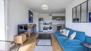 A modern apartment with a living room, kitchen, and dining area. - Appartement Conquistar - Welkeys (Cabourg)