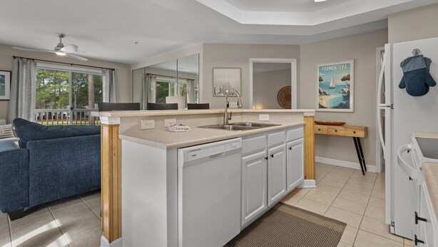 Een moderne keuken met een vaatwasser, een spoelbak en een zithoek met een bank en een tafel.