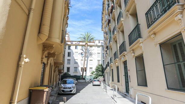A narrow street with parked cars and buildings on both sides. - Studio de la Buffa - Welkeys (Nice)