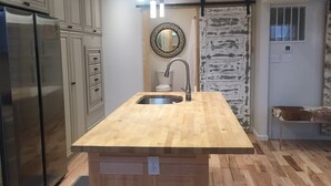 Eine Küche mit Kochinsel, Edelstahlkühlschrank und Holzböden.