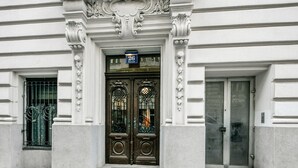 L'ingresso di un edificio con una doppia porta, un cartello sopra la porta e una piccola finestra a sinistra.
