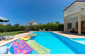 Ein Swimmingpool mit Liegestühlen und Schwimmspielzeug.