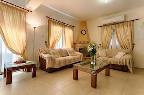 Cozy living space with two sofas, a fireplace, and a glass coffee table.