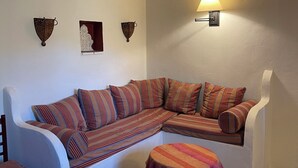 A corner living room with a sofa, a small table, and decorative wall sconces. - Family Cottage With Pool and Spectacular Views in a Rural Setting (Velez-Malaga)